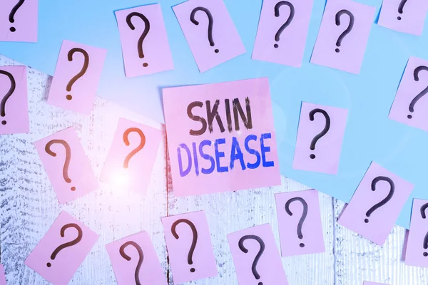 Text sign showing Skin Disease. Conceptual photo any of the diseases or disorders that affect the human skin Scribbled and crumbling papers with thick cardboard above wooden table.