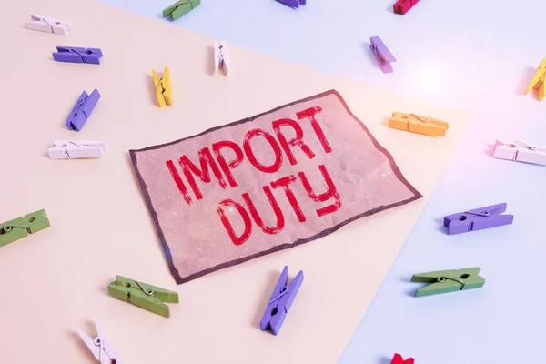 Kézírás szövegírás Import Duty. Fogalom jelentése adó által kivetett kormány áruk más országokból Színes ruhacsap papír üres emlékeztető sárga kék padló háttér iroda. — Stock Fotó
