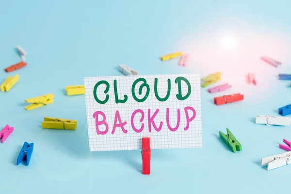 Text sign showing Cloud Backup. Conceptual photo enable customers to remotely access the provider s is services Colored clothespin rectangle square shaped paper light blue background.