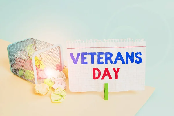 Handwriting text writing Veterans Day. Concept meaning a public holiday to honour US veterans and victims of all wars Trash bin crumpled paper clothespin empty reminder office supplies tipped.