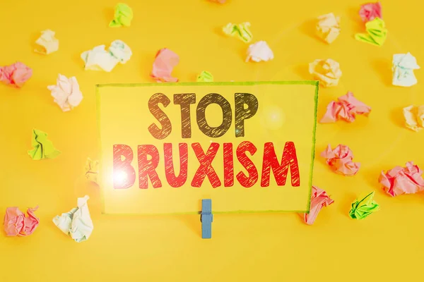 Word writing text Stop Bruxism. Business concept for put an end to a condition which you grind or clench the teeth Colored crumpled papers empty reminder white floor background clothespin. — Stock Photo, Image