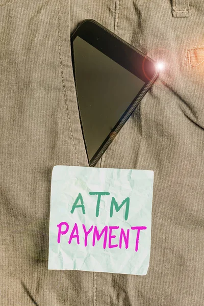 Writing note showing Atm Payment. Business photo showcasing Cashless Payment made through portable electronic devices Smartphone device inside trousers front pocket note paper. — 스톡 사진