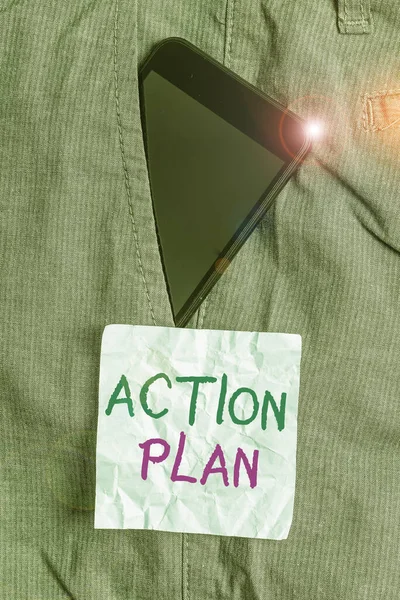 Writing note showing Action Plan. Business photo showcasing the detailed plan outlining actions needed to reach goals Smartphone device inside trousers front pocket note paper.