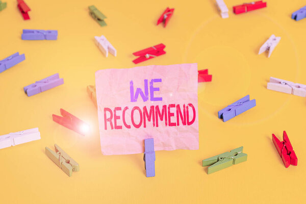 Handwriting text We Recommend. Concept meaning suggest that someone or something would be good or suitable Colored clothespin papers empty reminder yellow floor background office.