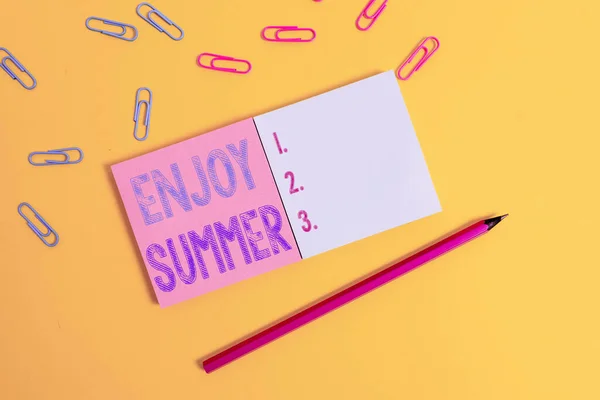 Woord schrijven tekst Geniet van de zomer. Zakelijk concept voor het nemen van een pauze van school en het doorbrengen van vakantie op het strand Gekleurde vierkante lege kleverige notitieblokken potlood clips effen kleur achtergrond. — Stockfoto