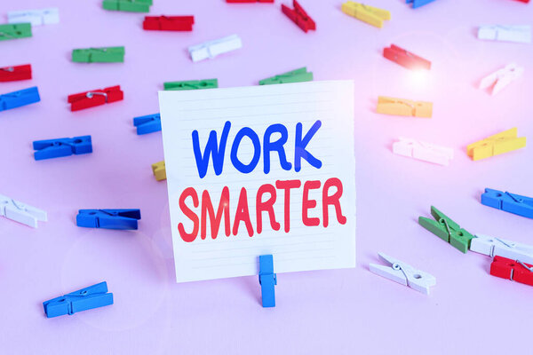 Word writing text Work Smarter. Business concept for figuring out order to reach goals in the most efficient way Colored clothespin papers empty reminder pink floor background office pin.