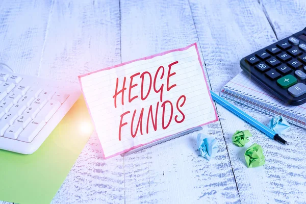 Handwriting text Hedge Funds. Concept meaning basically a fancy name for an alternative investment partnership Notepaper stand on buffer wire in between computer keyboard and math sheets. — Stok fotoğraf