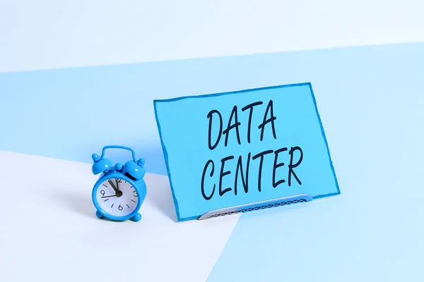 Conceptual hand writing showing Data Center. Business photo showcasing a repository that houses computing facilities like servers Alarm clock beside a Paper sheet placed on pastel backdrop. — ストック写真