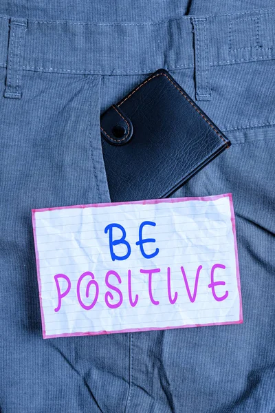 Text sign showing Be Positive. Conceptual photo giving cause for hope and confidence Without any doubt Small little wallet inside man trousers front pocket near notation paper. — Stock Photo, Image