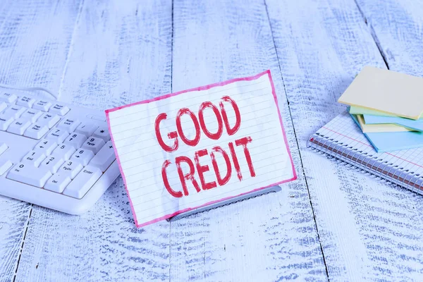 Handwriting text writing Good Credit. Concept meaning borrower has a relatively high credit score and safe credit risk Notepaper stand on buffer wire in between computer keyboard and math sheets.