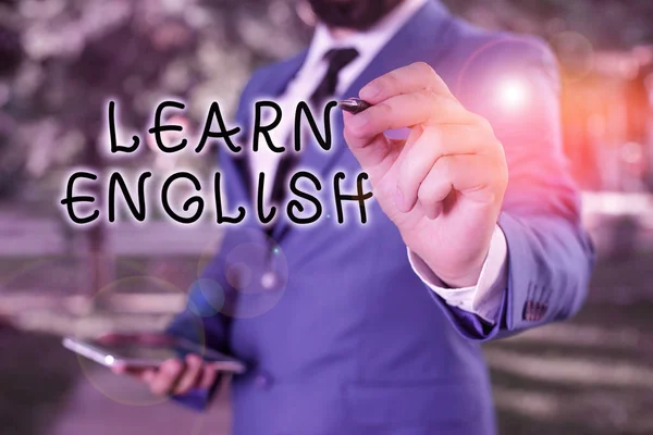 Text sign showing Learn English. Conceptual photo gain acquire knowledge in new language by study Businessman holds laptop and pen pointing into the copy space. — Stock Photo, Image