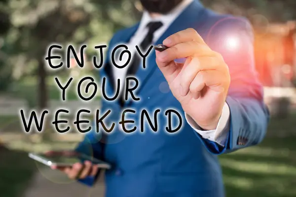 Znak tekstowy pokazujący Enjoy Your Weekend. Conceptual zdjęcie życząc komuś, że coś miłego wydarzy się na wakacjach Businessman trzyma laptopa i długopis wskazując w przestrzeni kopii. — Zdjęcie stockowe