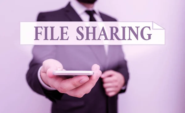 Text sign showing File Sharing. Conceptual photo transmit files from one computer to another over a network Male human wear formal work suit hold smart hi tech smartphone use one hand. — Stock Photo, Image