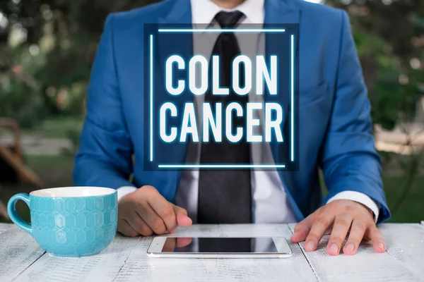 Writing note showing Colon Cancer. Business photo showcasing the development of cancer cells from the colon or rectum Businessman with pointing finger in front of him.