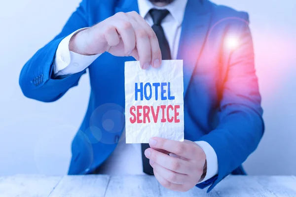 Texto de escritura de palabras Hotel Service. Concepto de negocio para proporcionar a los huéspedes un alojamiento cálido y otros servicios El hombre sostiene papel vacío con espacio para copias delante de él Copiar espacio . — Foto de Stock