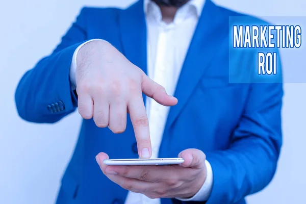 Handwriting text Marketing Roi. Concept meaning the contribution to profit attributable to marketing Businessman in the blue suite with lap top pointing with finger. — Stock Photo, Image