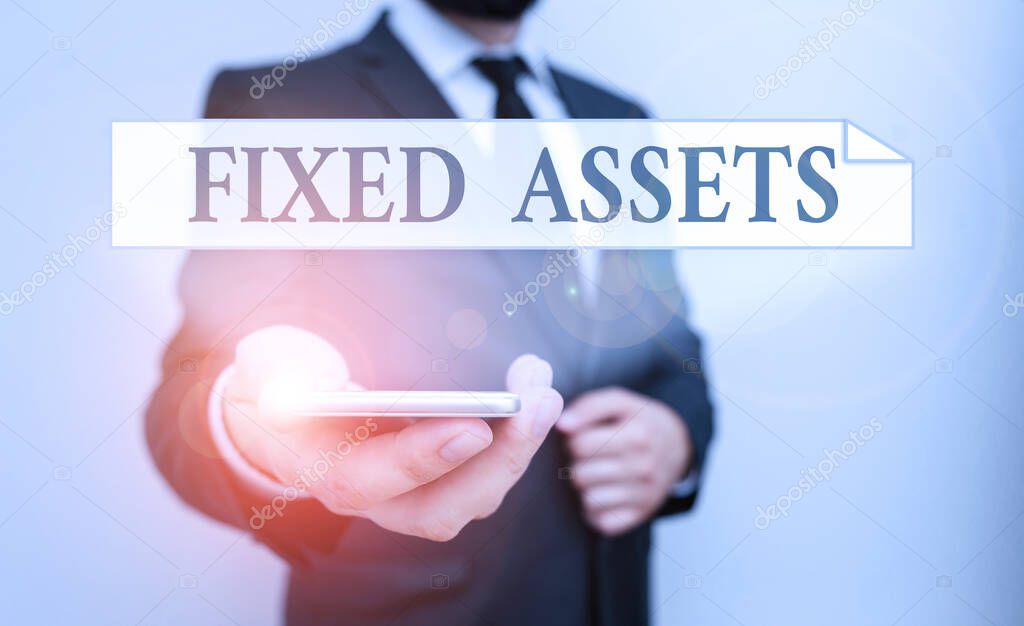 Text sign showing Fixed Assets. Conceptual photo longterm tangible piece of property or equipment a firm owns Male human wear formal work suit hold smart hi tech smartphone use one hand.