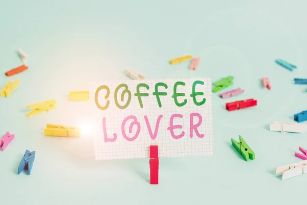 Text sign showing Coffee Lover. Conceptual photo a demonstrating who loves or has a fondness of drinking coffee Colored clothespin rectangle square shaped paper light blue background. — Stock Photo, Image