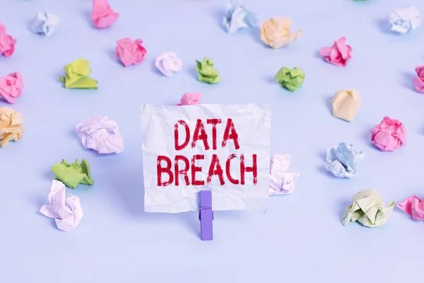 Handwriting text Data Breach. Concept meaning incident in which sensitive or confidential data is copied Colored crumpled papers empty reminder blue floor background clothespin.