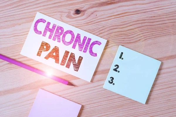 Text sign showing Chronic Pain. Conceptual photo pain that is ongoing and usually lasts longer than six months Colored clothespin papers empty reminder wooden floor background office.