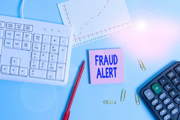 Escribir texto a mano Alerta de fraude. Concepto que significa alerta de seguridad colocada en la cuenta de tarjeta de crédito para la identidad robada Paper blue desk computer keyboard office study notebook chart numbers memo . — Foto de Stock