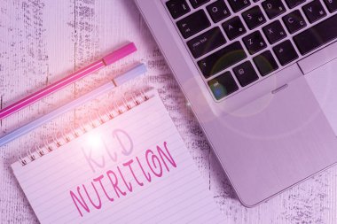 Kelime yazarı Kid Beslenme. Çocukların büyümesine ve öğrenmesine yardımcı olacak sağlıklı bir diyet konsepti. Metalik dizüstü bilgisayar, eski ahşap kalemler, eski ahşap masa..