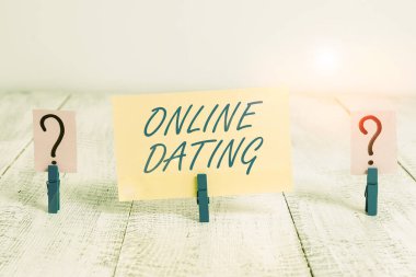 Online Flört 'ü gösteren kavramsal el yazısı. İnternette romantik bir eş aramak için ahşap masaya raptiye yerleştirilmiş kağıt parçacıkları..