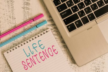 Sözcük yazma Hayat Cümlesi. Uzun süre hapis cezası için iş kavramı. Metalik dizüstü bilgisayar boş. Eski ahşap kalemler eski ahşap masa yatıyordu..