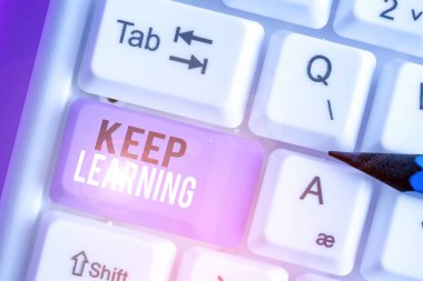 Öğrenmeye devam ettiğini gösteren bir not yazıyorum. Uzun ömürlü ve kendi güdümlü bilgi ve fikir arayışı gösteren iş fotoğrafı.