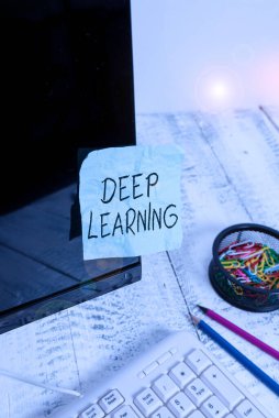 Deep Learning 'i gösteren bir not yazıyorum. Klavye ve durağan yakınındaki siyah bilgisayar ekranına yapıştırılmış not kağıdı öğrenme makinesinde kullanılan algoritmaların koleksiyonunu gösteren iş fotoğrafı.