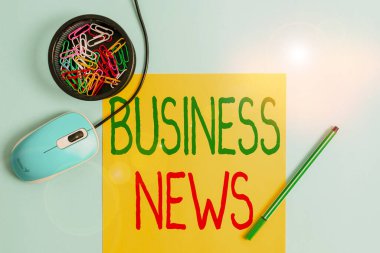 Business News 'i gösteren bir not yazıyorum. Bir gazete ya da haber dergisi Notebook 'unda ya da Pastel arkaplan üzerinde aygıtlar bulunan durağan iş fotoğrafları sergilenmektedir..