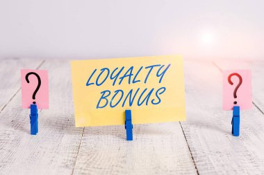 Sadakat bonusunu gösteren kavramsal el yazısı. Para ya da puan gibi iş fotoğrafı metni ödülü, tahta masaya raptiye takılmış sadık bir müşteri için veriliyor..