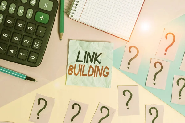 Writing note showing Link Building. Business photo showcasing process of acquiring hyperlinks from other website to your own Mathematics stuff and writing equipment above pastel colours background.