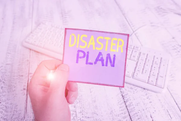 Scrivere testi in Word Disaster Plan. Business concept per delineare il modo in cui un'organizzazione risponde a un evento non pianificato uomo in possesso di promemoria colorato quadrato a forma di carta bianco tastiera pavimento in legno . — Foto Stock