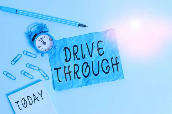 Handwriting text writing Drive Through. Concept meaning place where you can get type of service by driving through it Alarm clock clips notepad blank crushed sheet marker sky colored background.