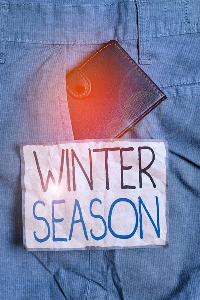 手書きのテキスト書き込み冬の季節。極と温帯地域での今年の寒い季節を意味する概念表記紙の近くの男のズボンのフロントポケット内の小さな財布. — ストック写真
