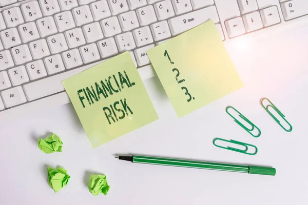 Handwriting text writing Financial Risk. Concept meaning any of various types of risk associated with financing Square green note paper with pencil on the white background.