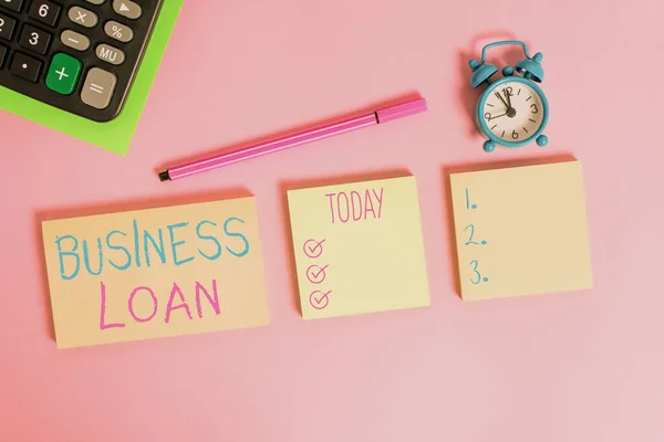 Handwriting text writing Business Loan. Concept meaning Loans provided to small businesses for various purposes Multicolor notepads alarm clock calculator sheet marker colored background.
