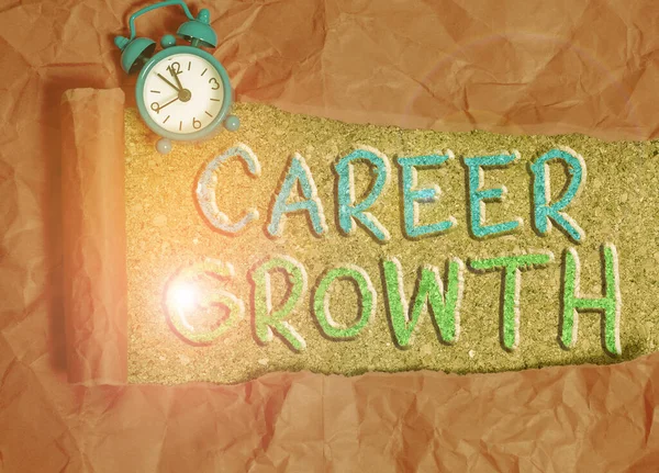Text sign showing Career Growth. Conceptual photo the process of making progress to better jobs or career Alarm clock and torn cardboard placed above a wooden classic table backdrop.
