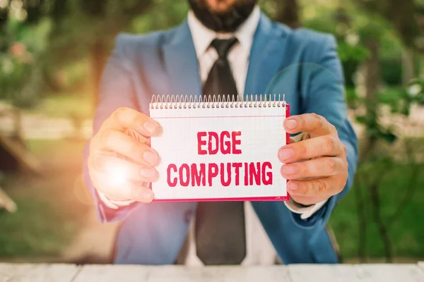 Handwriting text Edge Computing. Concept meaning practice of processing data near the edge of your network Man holds empty paper with copy space in front of him.