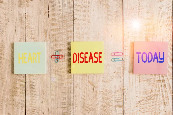 Text sign showing Heart Disease. Conceptual photo class of diseases that involve the heart or blood vessels Pastel colour note paper placed next to stationary above the wooden table. — Stock Photo, Image