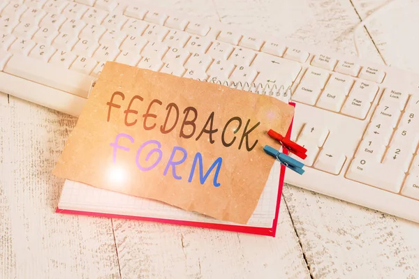 Handwriting text writing Feedback Form. Concept meaning way in which customer comment about product is obtained notebook paper reminder clothespin pinned sheet white keyboard light wooden.