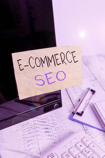 Escritura a mano conceptual que muestra E Commerce Seo. Muestra de fotos de negocios haciendo su tienda en línea más visible en el motor de búsqueda Nota papel pegado a la pantalla en negro cerca del teclado estacionario . — Foto de Stock