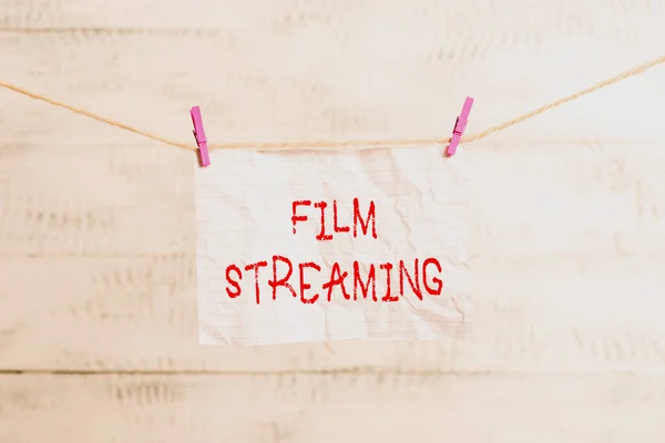 Handwriting text writing Film Streaming. Concept meaning act of watching sound or video directly from the internet Clothesline clothespin rectangle shaped paper reminder white wood desk. — Stock Photo, Image