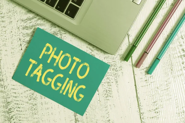 Textschild mit Foto-Tagging. Konzeptfoto identifizieren Sie jemanden auf dem Foto, das Sie teilen Social Media Trendy Metallic Laptop Blank Haftblock drei Stifte liegen Vintage-Tisch. — Stockfoto