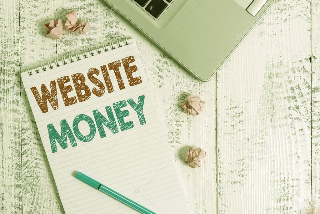 Conceptual hand writing showing Website Money. Business photo showcasing Refers to the website we want to promote Where money is earned Laptop ruled spiral notepad crushed paper balls wooden table.