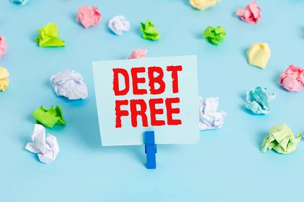 Signo de texto que muestra Debt Free. Foto conceptual no posee dinero o cosas a cualquier individuo o empresas Papeles arrugados coloreados recordatorio vacío azul piso fondo pinza de ropa . — Foto de Stock