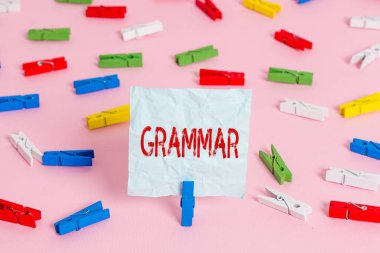 Gramer dersini gösteren bir not yazıyorum. Tüm sistem yapı dili sözdizimi ve morfolojisini gösteren iş fotoğrafı Renkli çamaşır iğnesi kağıtları boş hatırlatıcı pembe ofis broşu.