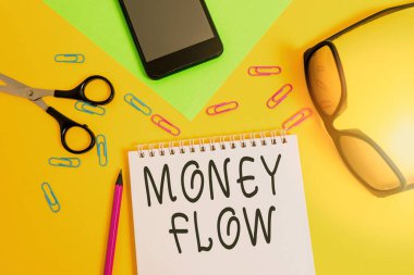 Para akışını gösteren bir not yazıyorum. İş fotoğrafında para artışı ya da azalması görülüyor. İş sayfası, kalem, akıllı telefon, makas, gözlük, renk arkaplanı..