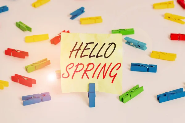 Escribiendo nota mostrando Hola Primavera. Foto de negocios mostrando la bienvenida a la temporada de la floración de las flores Fin de invierno Papeles de pinza de ropa de colores recordatorio vacío piso blanco fondo oficina . — Foto de Stock